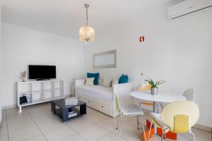 a bedroom with a bed and a table and chairs at Casa De Pardal in Quarteira