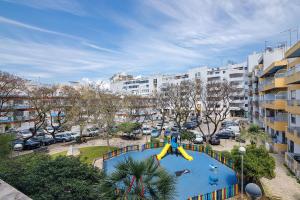 a large swimming pool with a slide in a city at Casa De Pardal in Quarteira