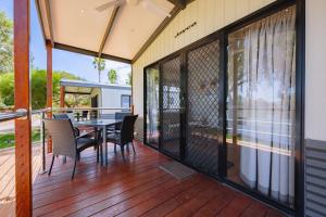 a screened in porch with a table and chairs at Rivergardens Holiday Park Mildura in Gol Gol
