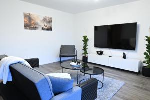 a living room with a blue couch and a tv at Timos Ferienwohnung in Schmallenberg