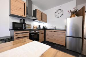a kitchen with a refrigerator and a clock on the wall at Timos Ferienwohnung in Schmallenberg
