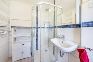 a white bathroom with a sink and a shower at Freundliche 50m² Ferienwohnung in Sonnenberg +8 photos