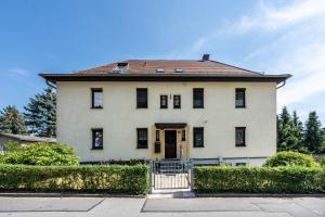 a large white house with a gate in front of it at Freundliche 50m² Ferienwohnung in Sonnenberg