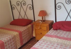 a bedroom with two beds and a lamp on a night stand at Beach apartment in Los Cristianos in Los Cristianos