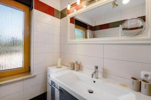 a bathroom with a sink and a mirror at Ferienwohnung Gabi in Malchow +12 photos