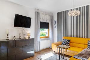 a living room with a yellow couch and a window at Ferienwohnung Gabi in Malchow
