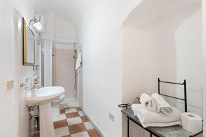 a white bathroom with a sink and a toilet at Romeo e Giulietta Rooms in Bosa +54 photos