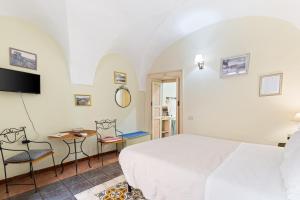 a bedroom with a bed and a table and chairs at Romeo e Giulietta Rooms in Bosa
