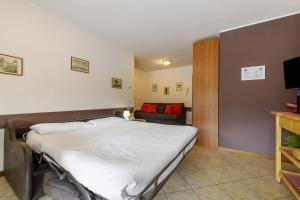 a large bed in a room with a couch at Como's Lake Mountains beb in Cremeno