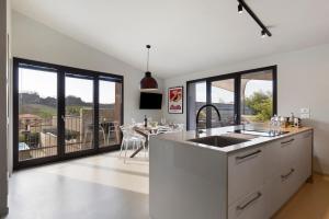 a kitchen with large windows and a dining room with a table at Isola Degli Angeli in Reggello