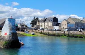 a small boat in the water next to a harbor at Appartement T2 face à la mer in Saint-Vaast-la-Hougue