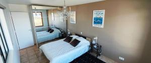 a bedroom with two beds and a mirror at Appartement T2 face à la mer in Saint-Vaast-la-Hougue