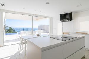 a white kitchen with a view of the ocean at Villa Lizo in El Campello