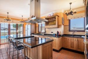 a kitchen with wooden cabinets and black counter tops at Villa María in Tinajo