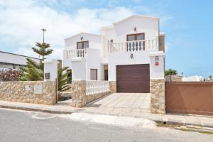 a white house with a gate and a fence at Villa María in Tinajo