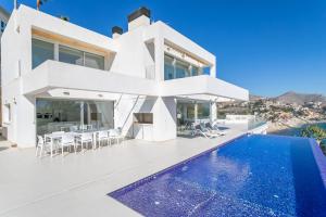 a white villa with a swimming pool and a house at Villa Lizo in El Campello