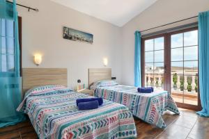 two beds in a room with a window at Villa María in Tinajo +19 photos