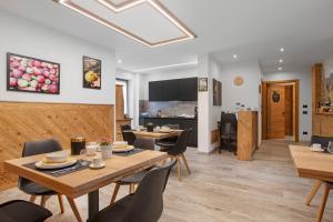 a dining room with tables and chairs and a kitchen at La Douce Pomme in Saint-Pierre