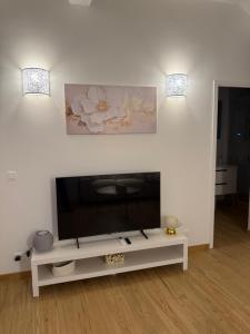 a living room with a flat screen tv sitting on a white table at Très Grand studio neuf 50 m du port Lovely charrons 2 in Saint-Tropez