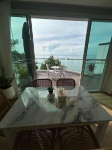 a table and chairs with a view of the ocean at P8 Cliff House Stunning Seaview in Ban Ko Kok