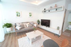 a living room with a couch and a tv at P8 Cliff House Stunning Seaview in Ban Ko Kok