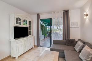 a living room with a couch and a tv at Great Bungalow Maspalomas in Maspalomas
