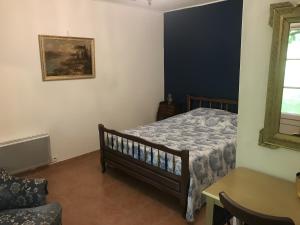 a bedroom with a bed with a blue wall at Le Gite Amical des Chiens in Penne-dʼAgenais