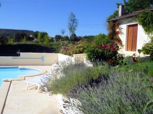 a garden with a swimming pool and some flowers at Le Gite Amical des Chiens in Penne-dʼAgenais