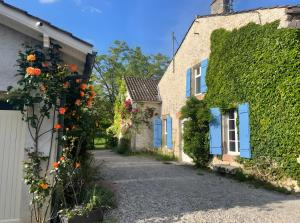 an alley between two houses with flowers on the side at Le Gite Amical des Chiens in Penne-dʼAgenais