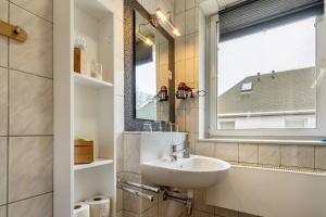 a bathroom with a sink and a mirror and a window at Ferienwohnung Deluxe in Radeberg +29 photos