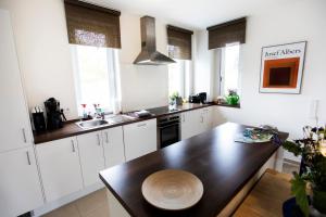 a kitchen with white cabinets and a wooden table at Ferienwohnung Auf Dem Schönen Felde in Brilon