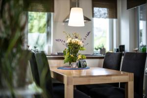 a wooden table with a vase of flowers on it at Ferienwohnung Auf Dem Schönen Felde in Brilon