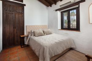 a bedroom with a bed in a room with a window at Finca Mojito in Cómpeta +26 photos
