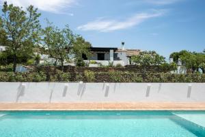 a swimming pool with a house in the background at Finca Mojito in Cómpeta