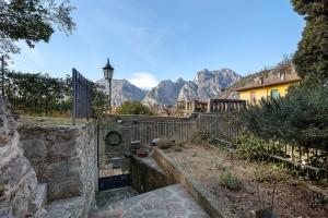 a garden with a fence and mountains in the background at Villa G By Immobilux in Nago-Torbole