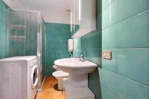 a bathroom with a white sink and a toilet at Villa G By Immobilux in Nago-Torbole +18 photos