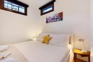 a bedroom with a white bed with two windows at Villa G By Immobilux in Nago-Torbole