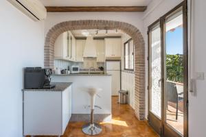a kitchen with white cabinets and a brick archway at Casa Romantica in Salobreña