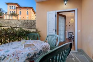 a table and chairs on a balcony with a table and a door at Villa G By Immobilux in Nago-Torbole