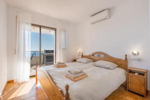 a bedroom with a large white bed with a balcony at Casa Romantica in Salobreña +27 photos
