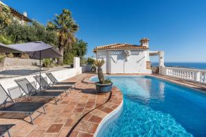 a swimming pool with chairs and a villa at Casa Romantica in Salobreña