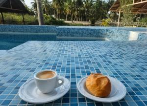 a cup of coffee and a pastry on a table at L'île de Marie-Jo in Assinie +23 photos