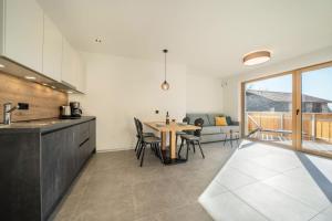 a kitchen and dining room with a table and chairs at Sunnig Apartment Sonnenschein in Vollan