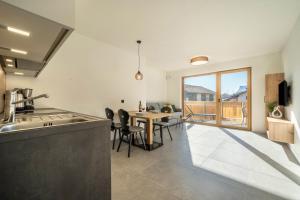 a kitchen and dining room with a table and chairs at Sunnig Apartment Sonnenschein in Vollan +12 photos