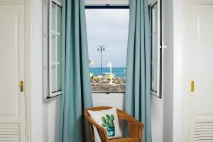 a wicker chair sitting in front of a window with blue curtains at Bungalow 4 - Caleta Campos in Arrieta