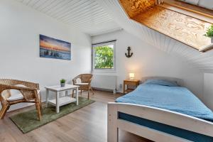 a bedroom with a bed and a table and chairs at Zwischen den Wellen in Oldenburg in Holstein