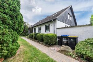 a house with two trash cans in front of it at Zwischen den Wellen in Oldenburg in Holstein