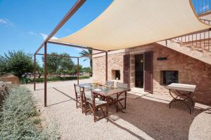 a patio with a table and chairs under a tent at Son Rossinyol Nou - Sa Bovera in Islas Baleares