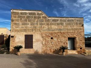 an old stone building with two palm trees in front of it at Son Rossinyol Nou - Sa Bovera in Islas Baleares +2 photos