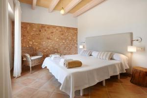 a bedroom with a white bed and a chair at Son Rossinyol Nou - Sa Bovera in Islas Baleares
